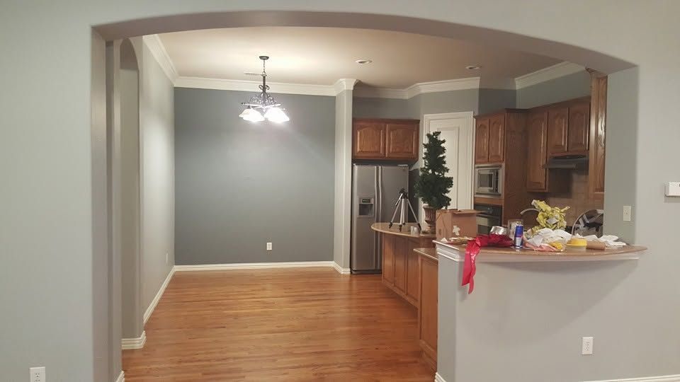 Open living room and kitchen with hardwood floors, gray walls, and a breakfast bar decorated for the holidays