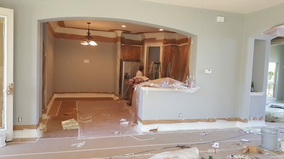 Partially renovated room with exposed flooring, arched pass-through, and construction debris