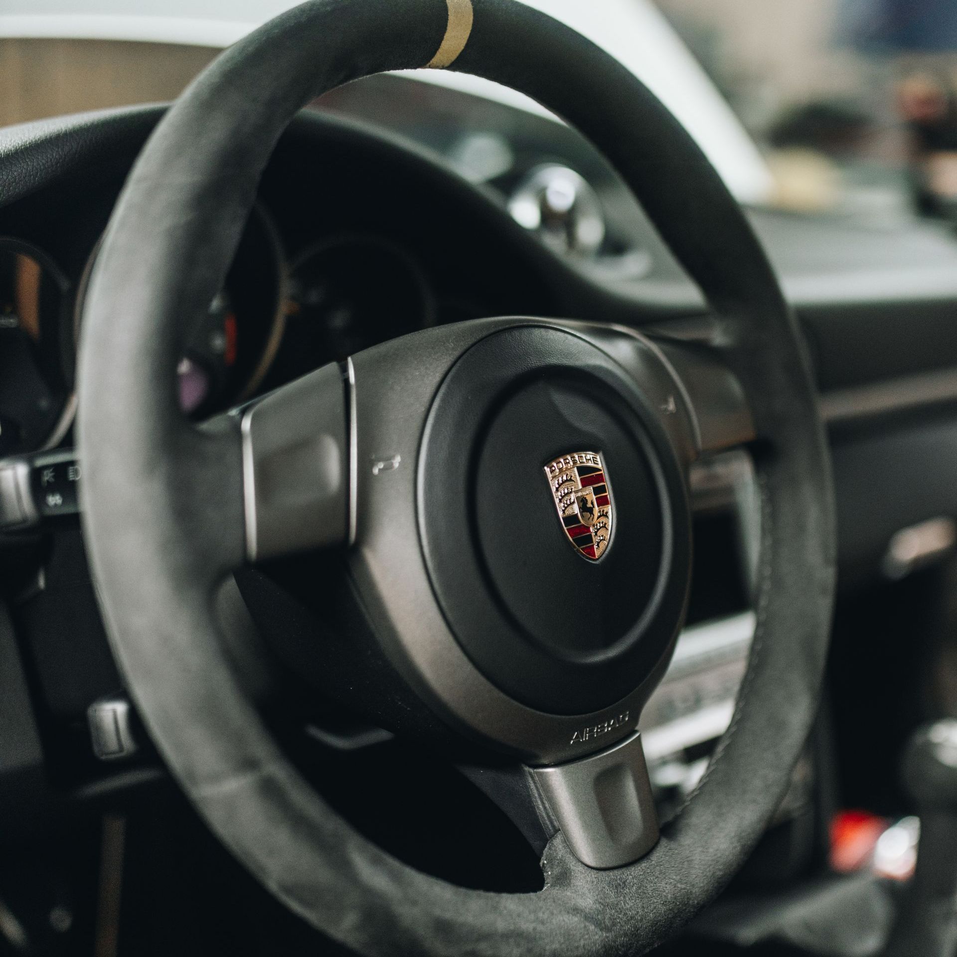 a close up of a porsche steering wheel in a car
