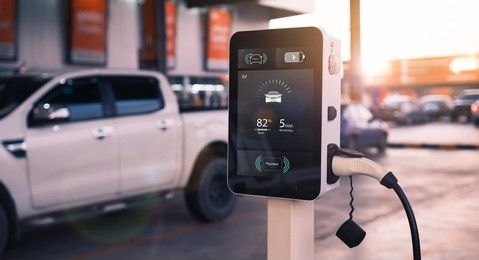 An electric car is being charged at a charging station.