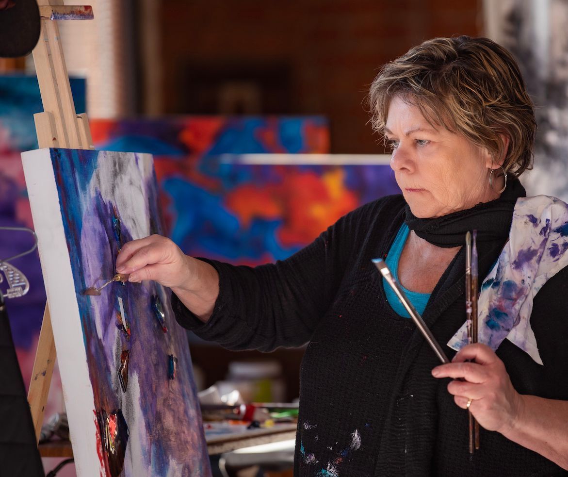 Karen Klucowicz painting with palette knife in studio.