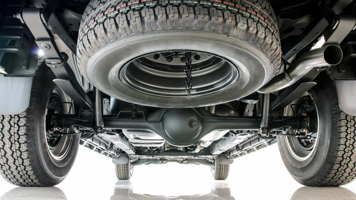The underside of a truck with a spare tire attached to it.