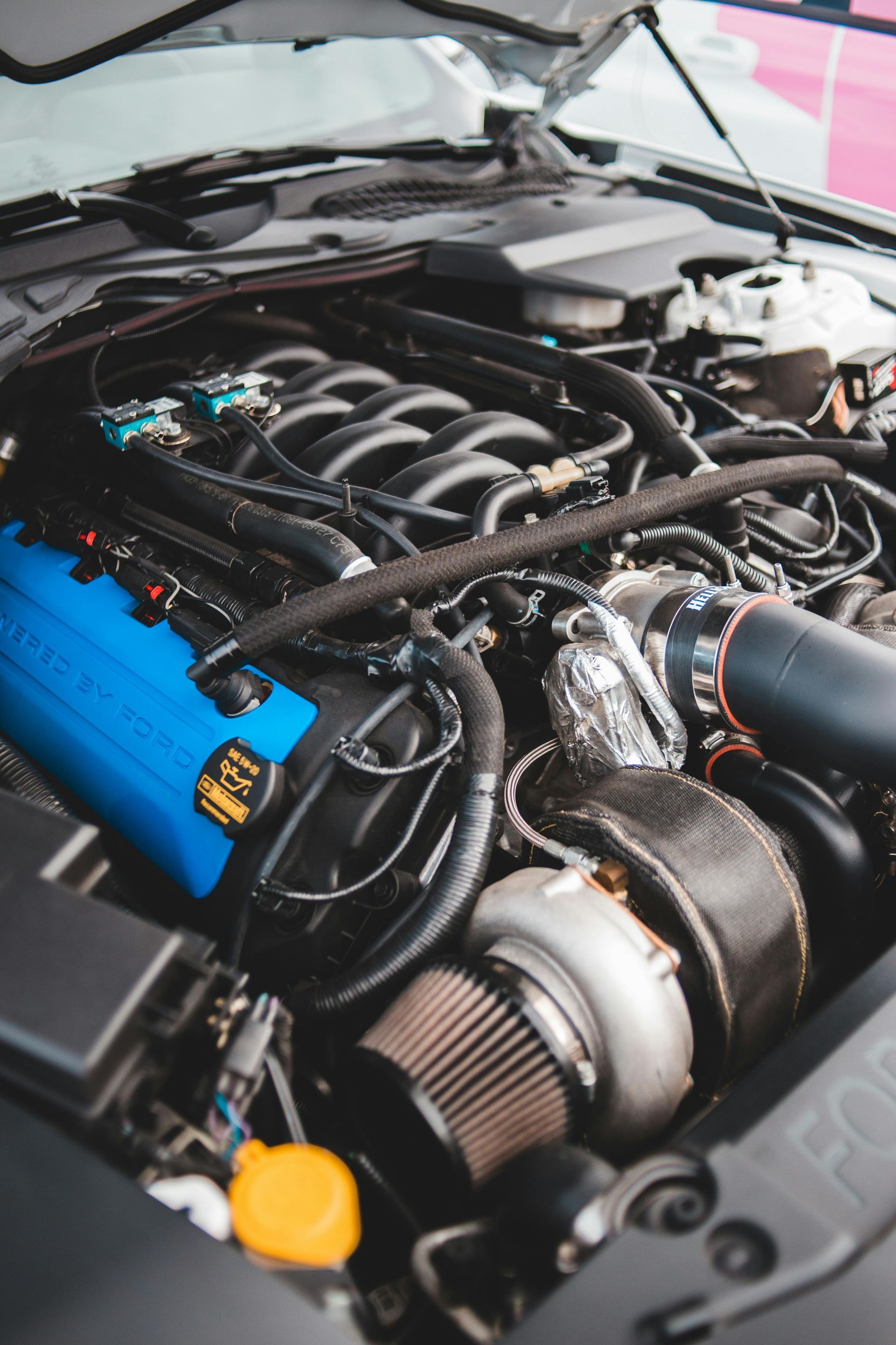 A close up of a car engine with the hood open.