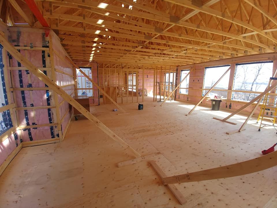 Une grande pièce en construction avec beaucoup de poutres en bois