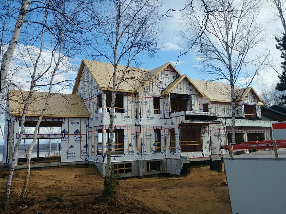 Une grande maison est en construction au milieu d'une forêt