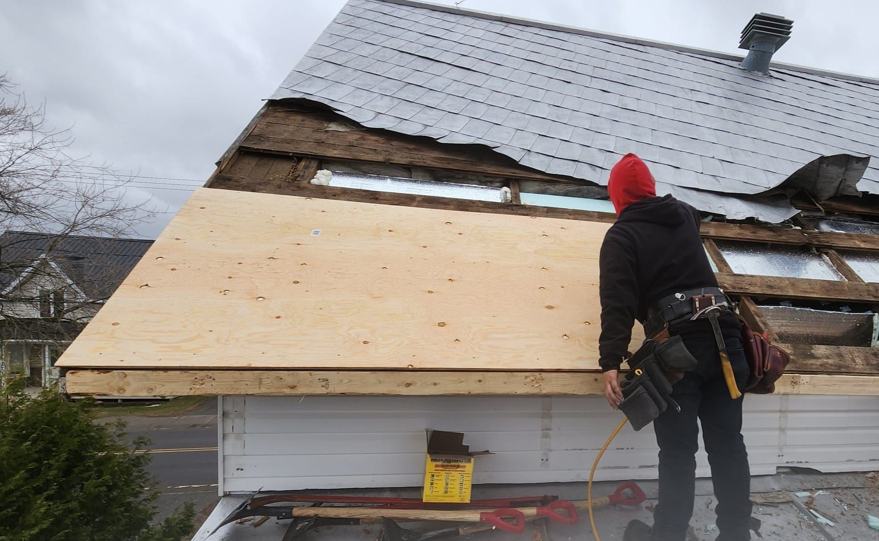 Un homme travaille sur le toit d'une maison.