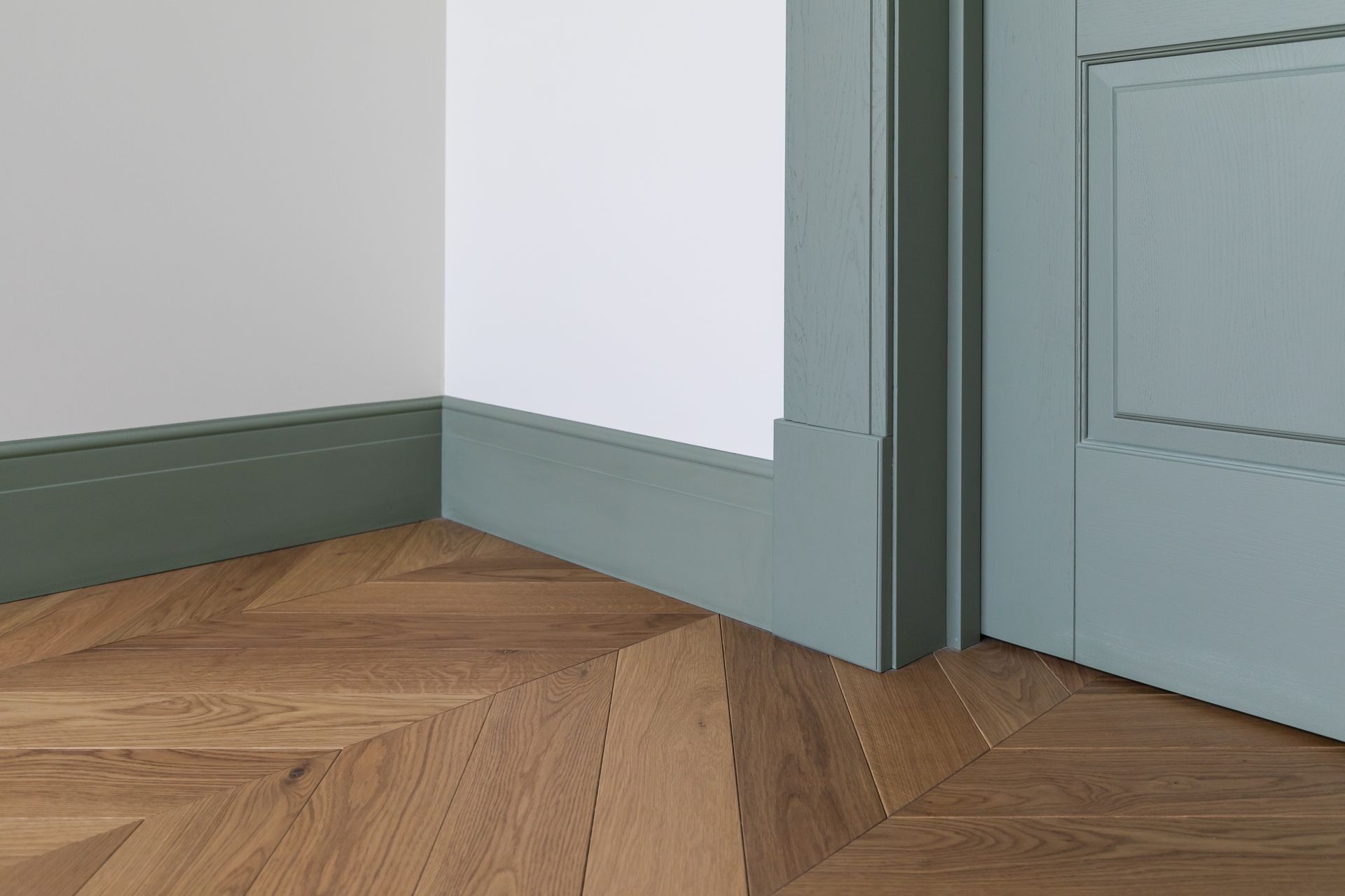 Un coin d'une pièce avec un plancher en bois et une porte.