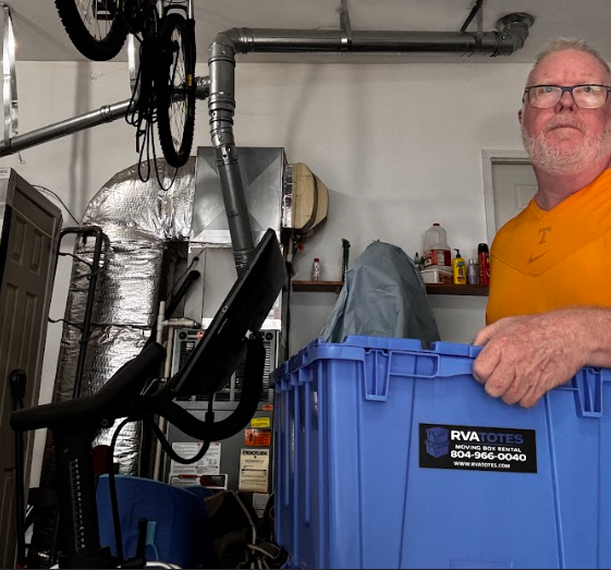 Person carrying a reusable moving tote filled with items