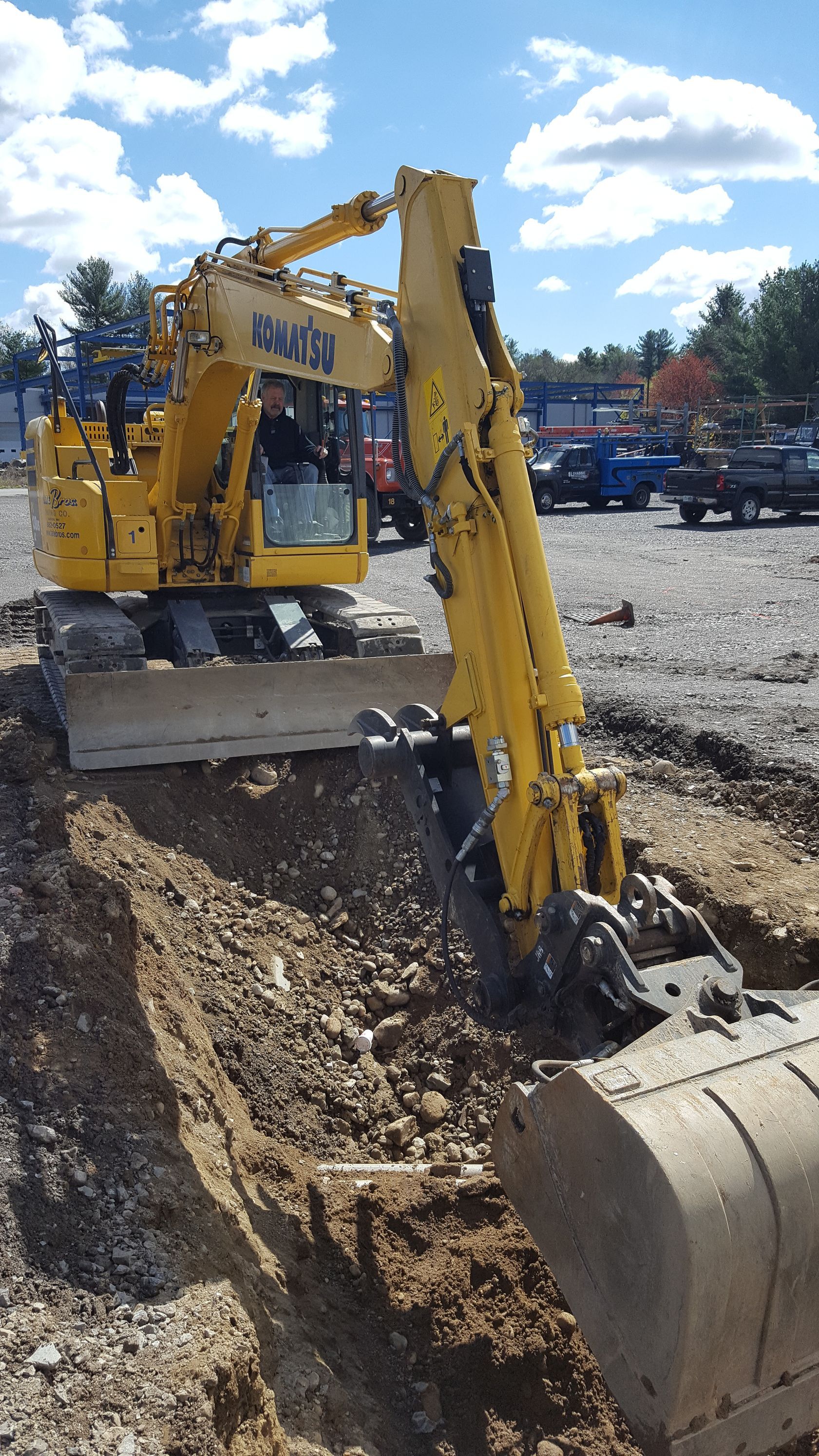 A yellow excavator is digging a hole in the dirt on a construction site
