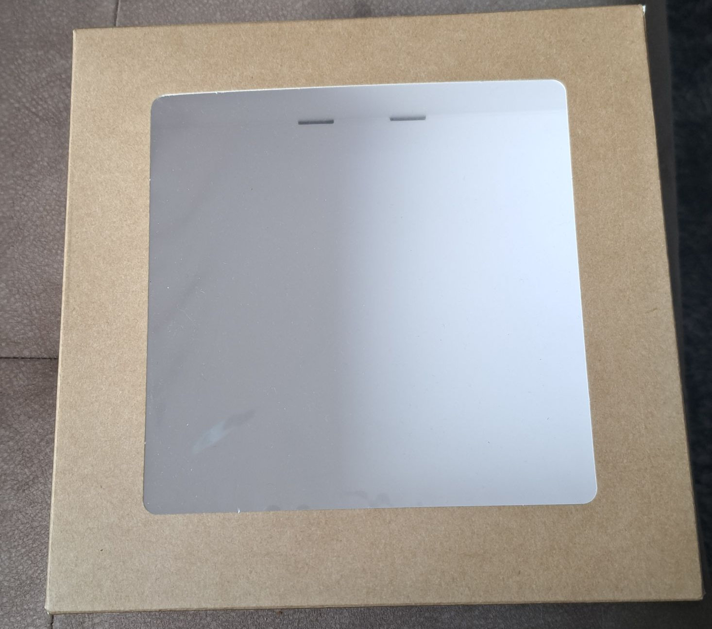 Bruine kartonnen fotolijst met een vierkante, doorzichtig plastic in het midden.