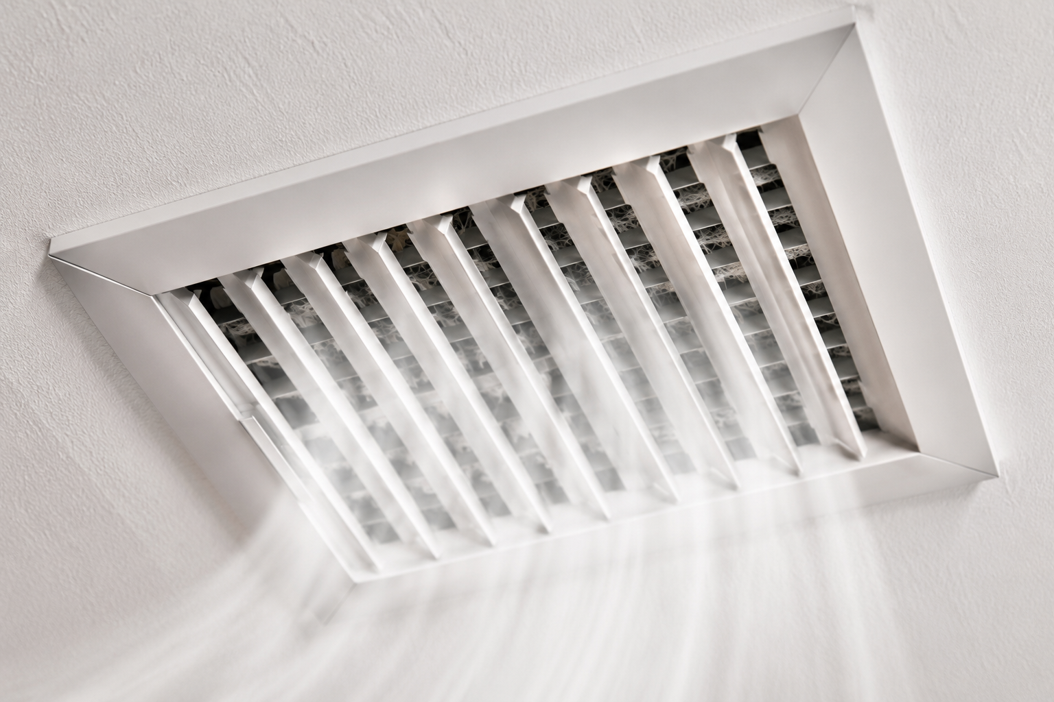 Ceiling air vent with metal slats in a white ceiling