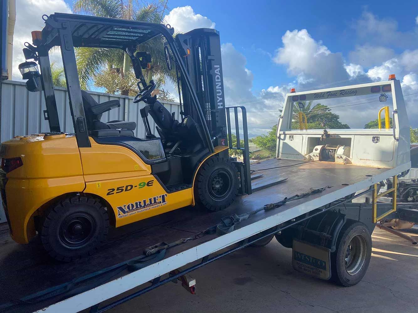 A Yellow Forklift is Sitting on Top of a Tow Truck — Cape York Towing & Transport in Musgrave, QLD