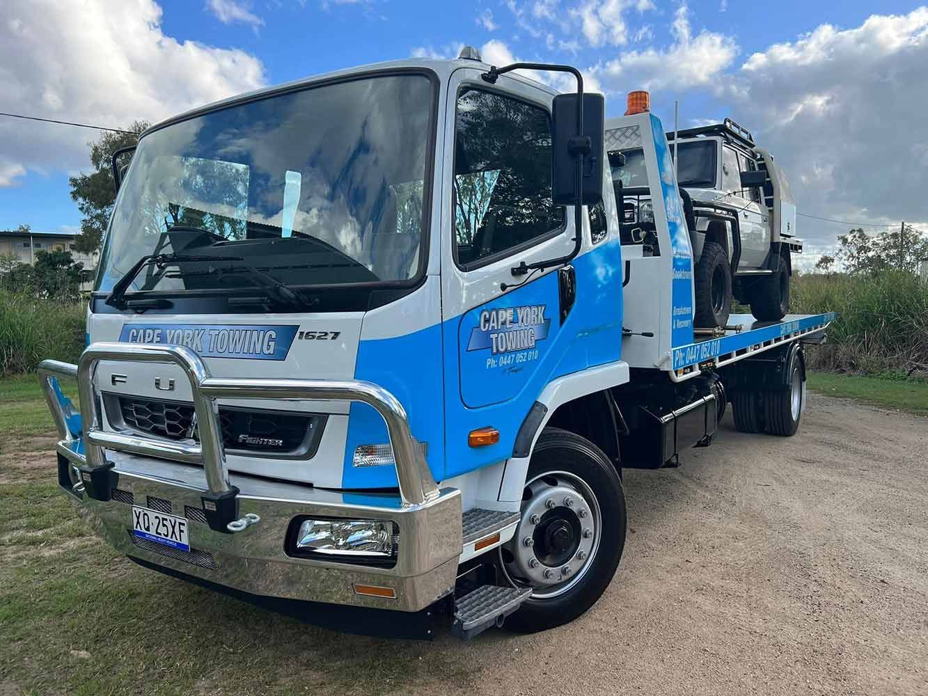 A Blue and White Tow Truck is Parked on a Dirt Road — Cape York Towing & Transport in Seisia, QLD