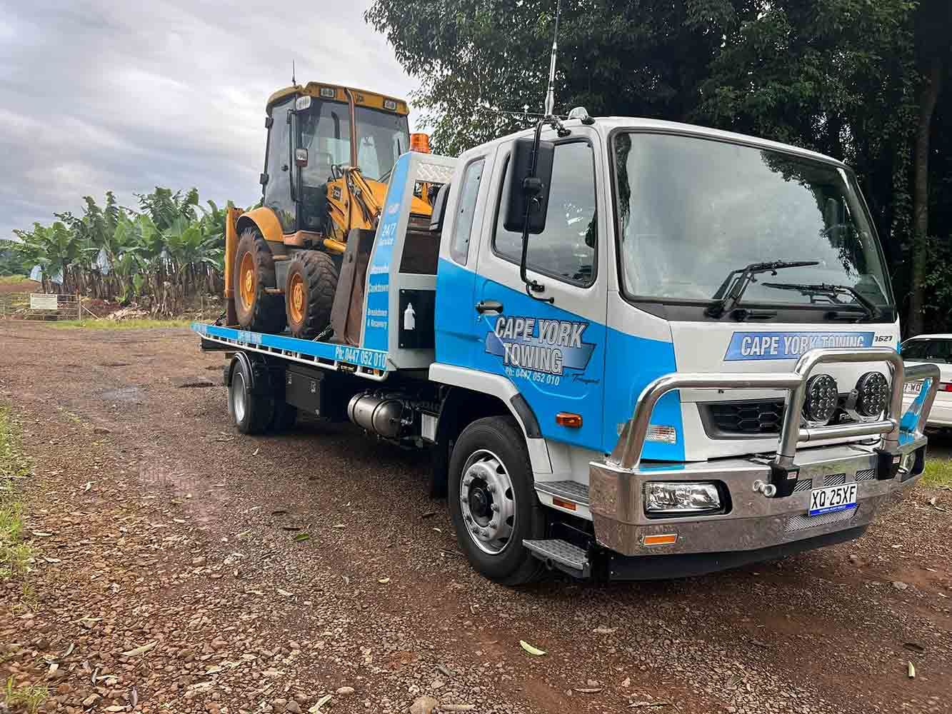 A Tow Truck is Carrying a Tractor on the Back of It — Cape York Towing in Rockhampton, QLD