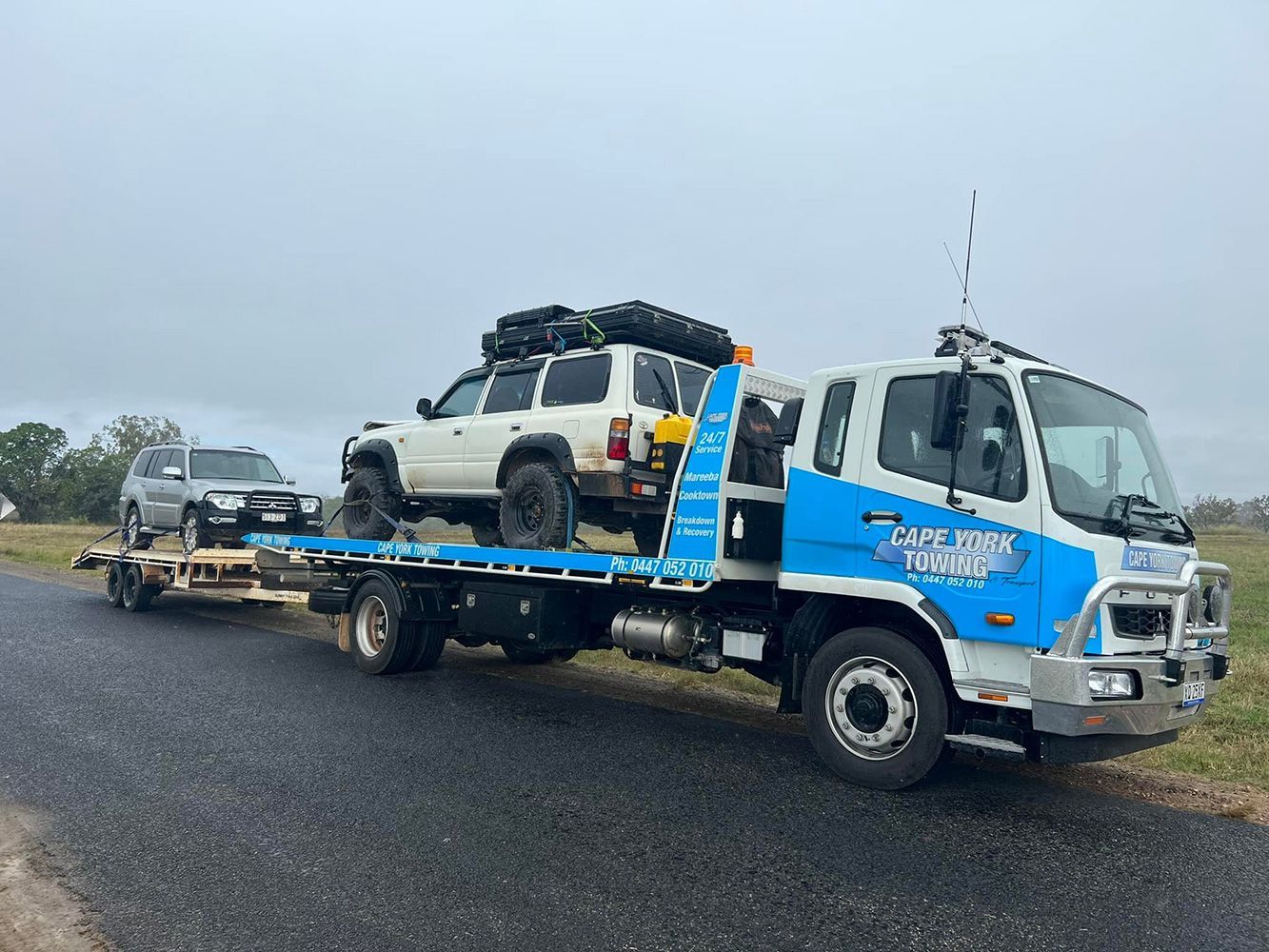 A Tow Truck is Carrying Two Cars on a Trailer — Cape York Towing & Transport in Bramwell, QLD