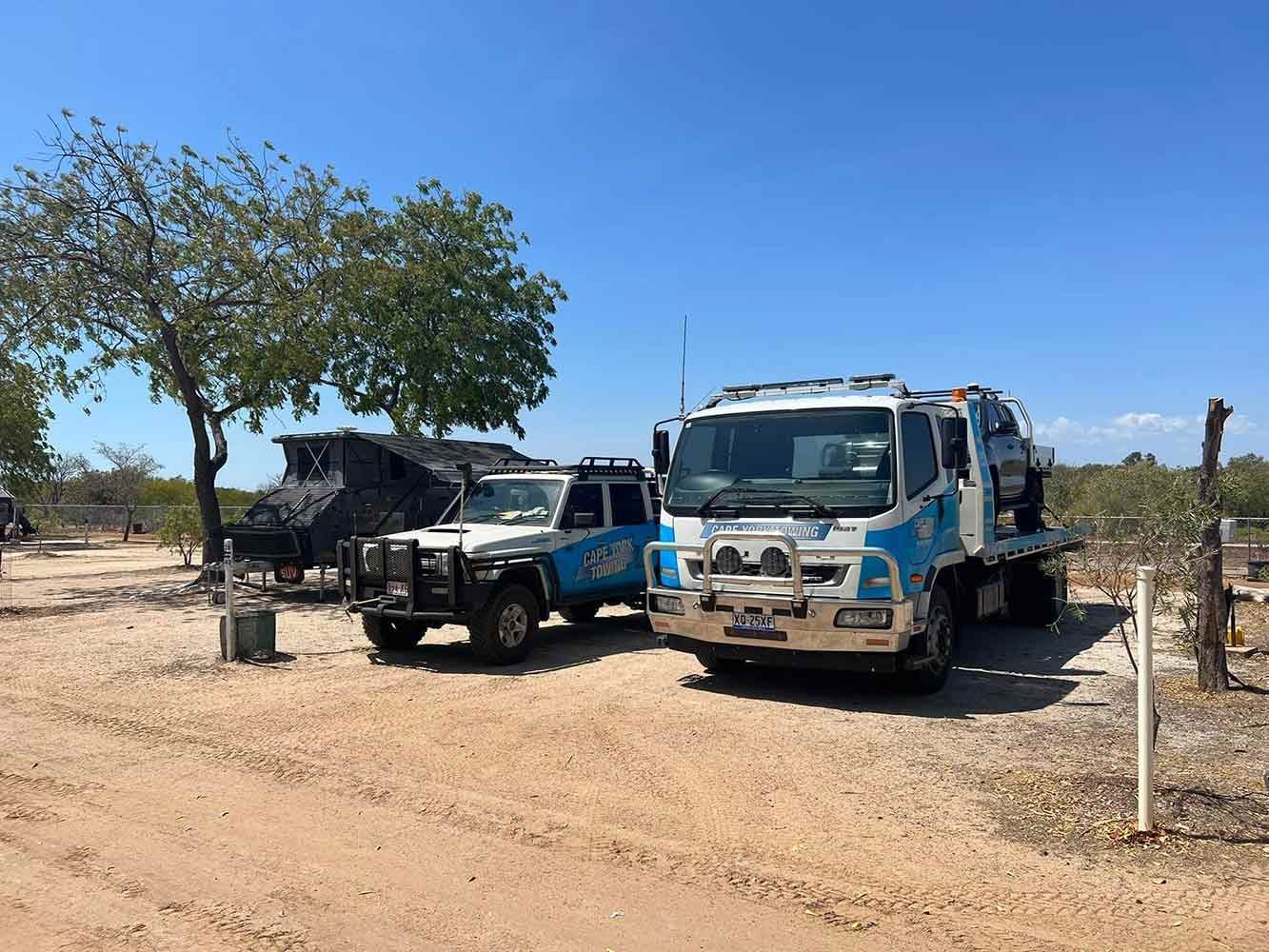 Two Tow Trucks Are Parked Next to Each Other on a Dirt Road — Cape York Towing & Transport in Cooktown, QLD