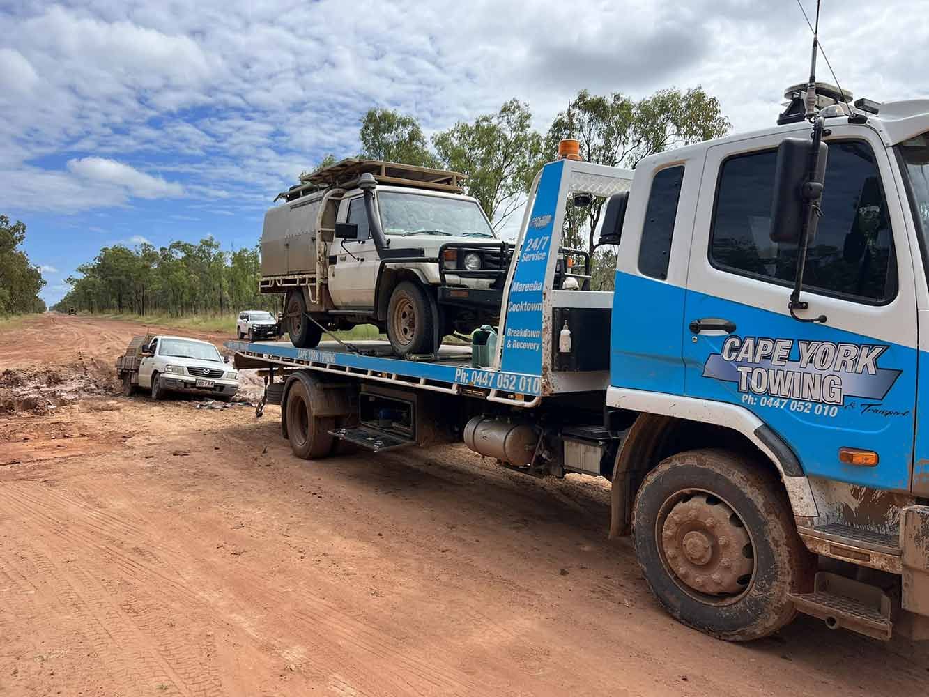 A Tow Truck is Towing a Car on a Dirt Road — Cape York Towing & Transport in Seisia, QLD
