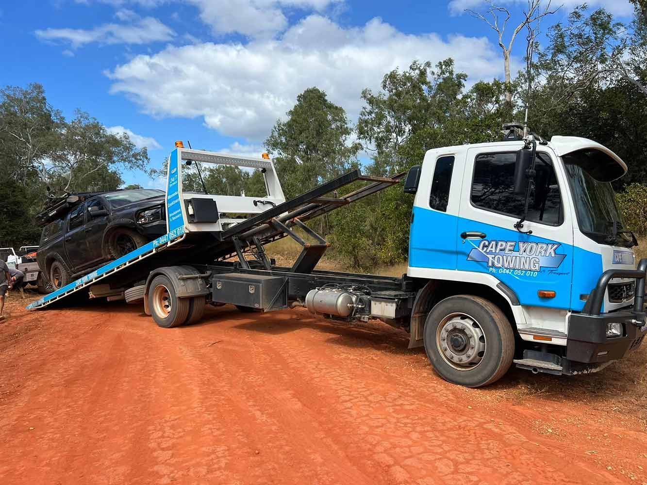 A Tow Truck is Towing a Car on a Dirt Road — Cape York Towing & Transport in Weipa, QLD