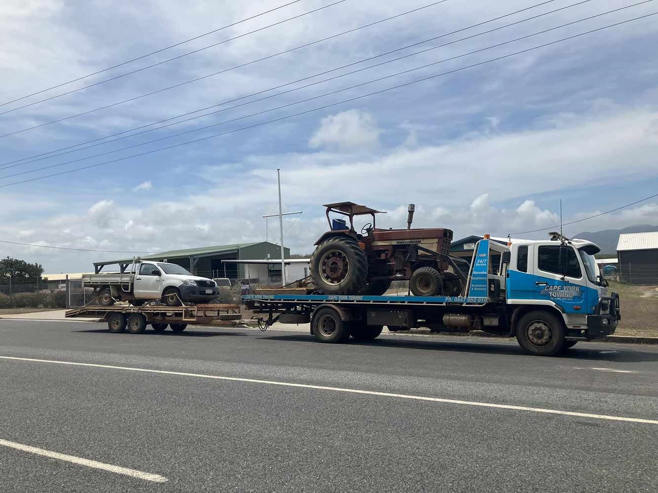 A Tow Truck is Carrying a Tractor and a Truck on a Trailer — Cape York Towing in Bamaga, QLD