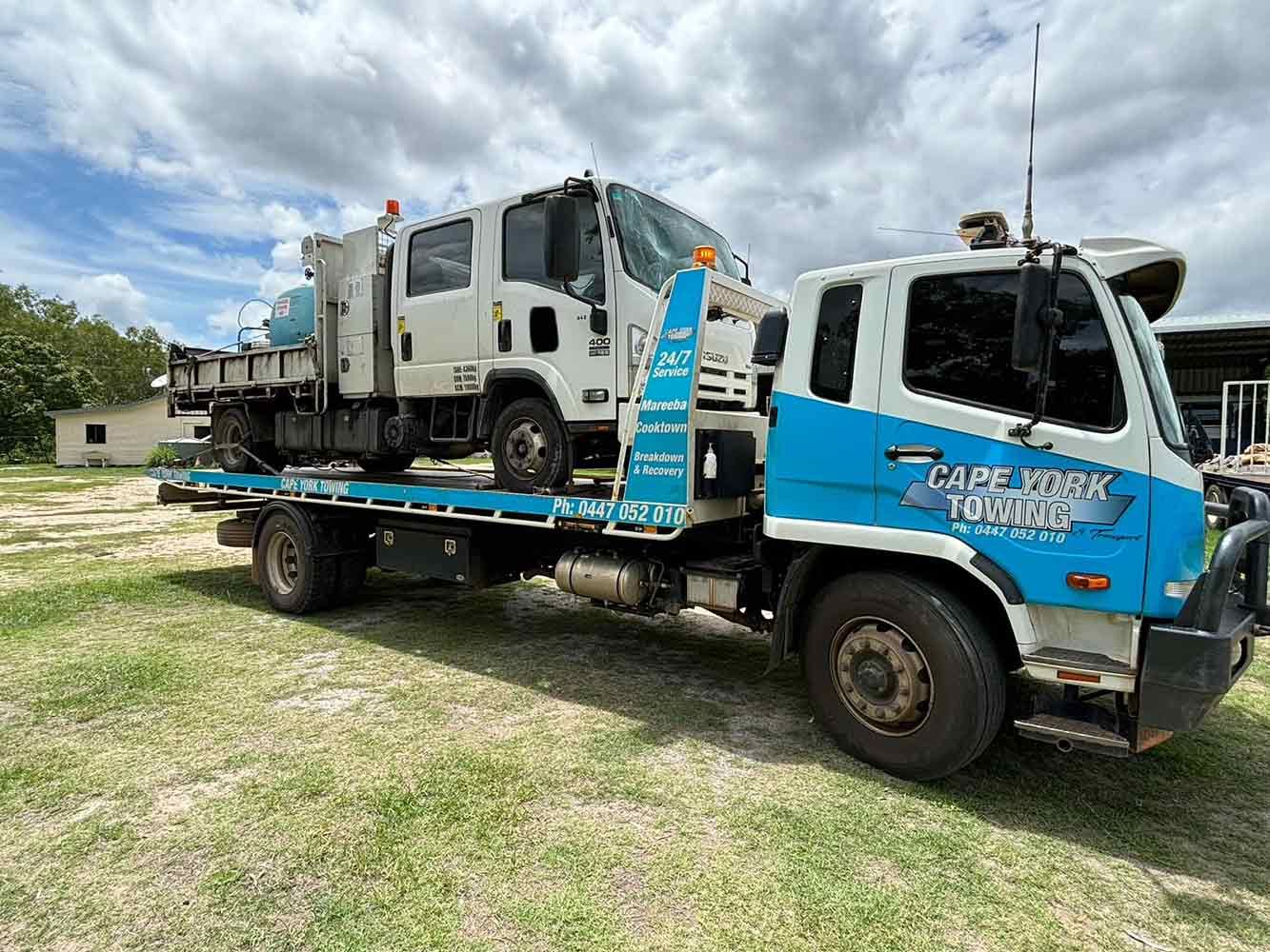 A Blue and White Tow Truck is Parked in a Grassy Field — Cape York Towing in Bamaga, QLD
