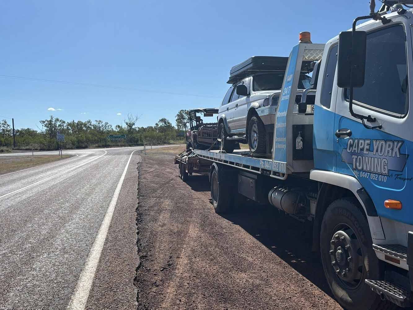 A Tow Truck is Carrying Two Cars on the Back of It — Cape York Towing in Bamaga, QLD
