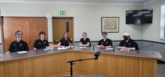 Students of youth court sitting at a table.