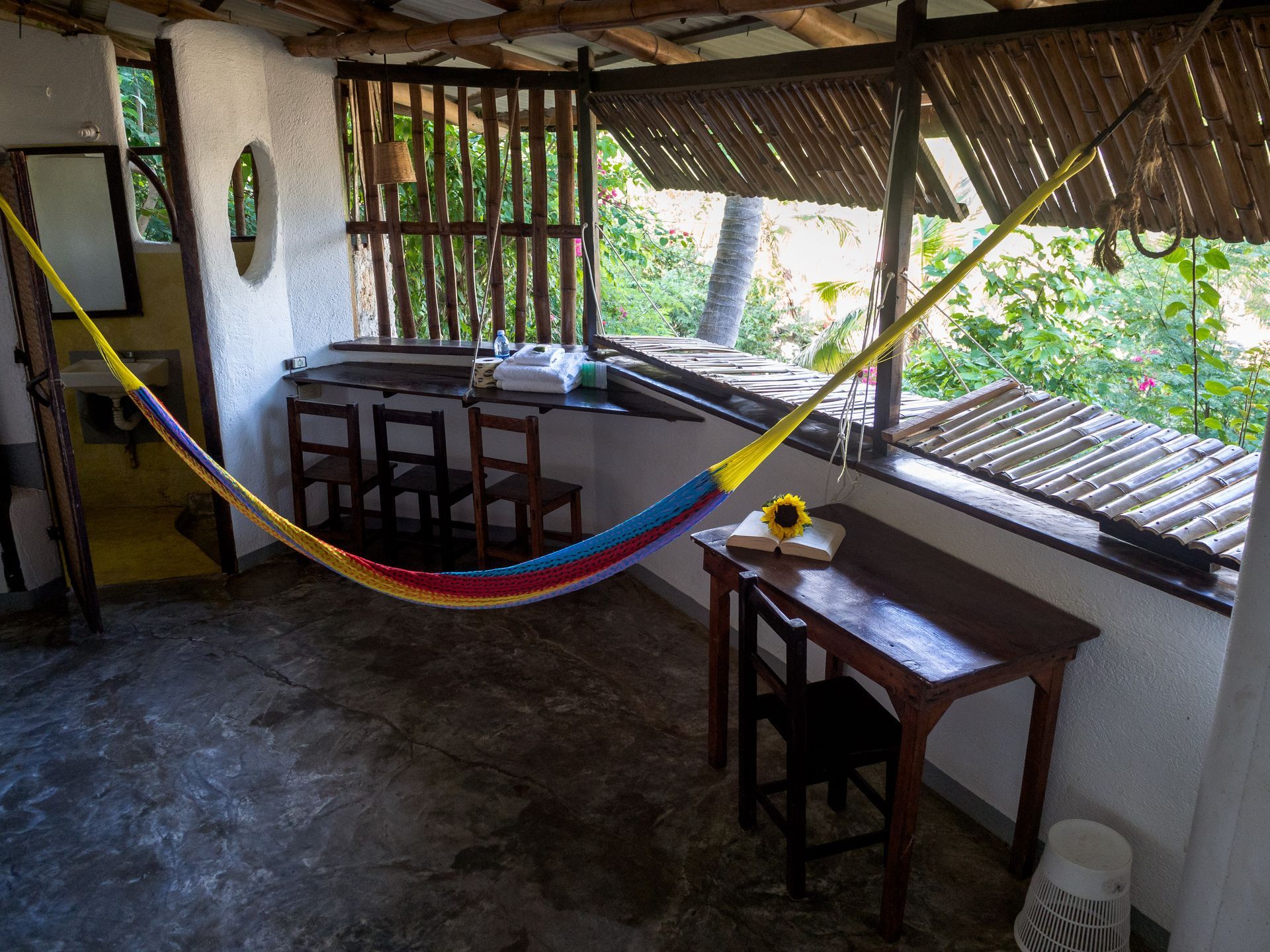 Porche cubierto con hamaca, escritorio y sillas en posada del arquitecto