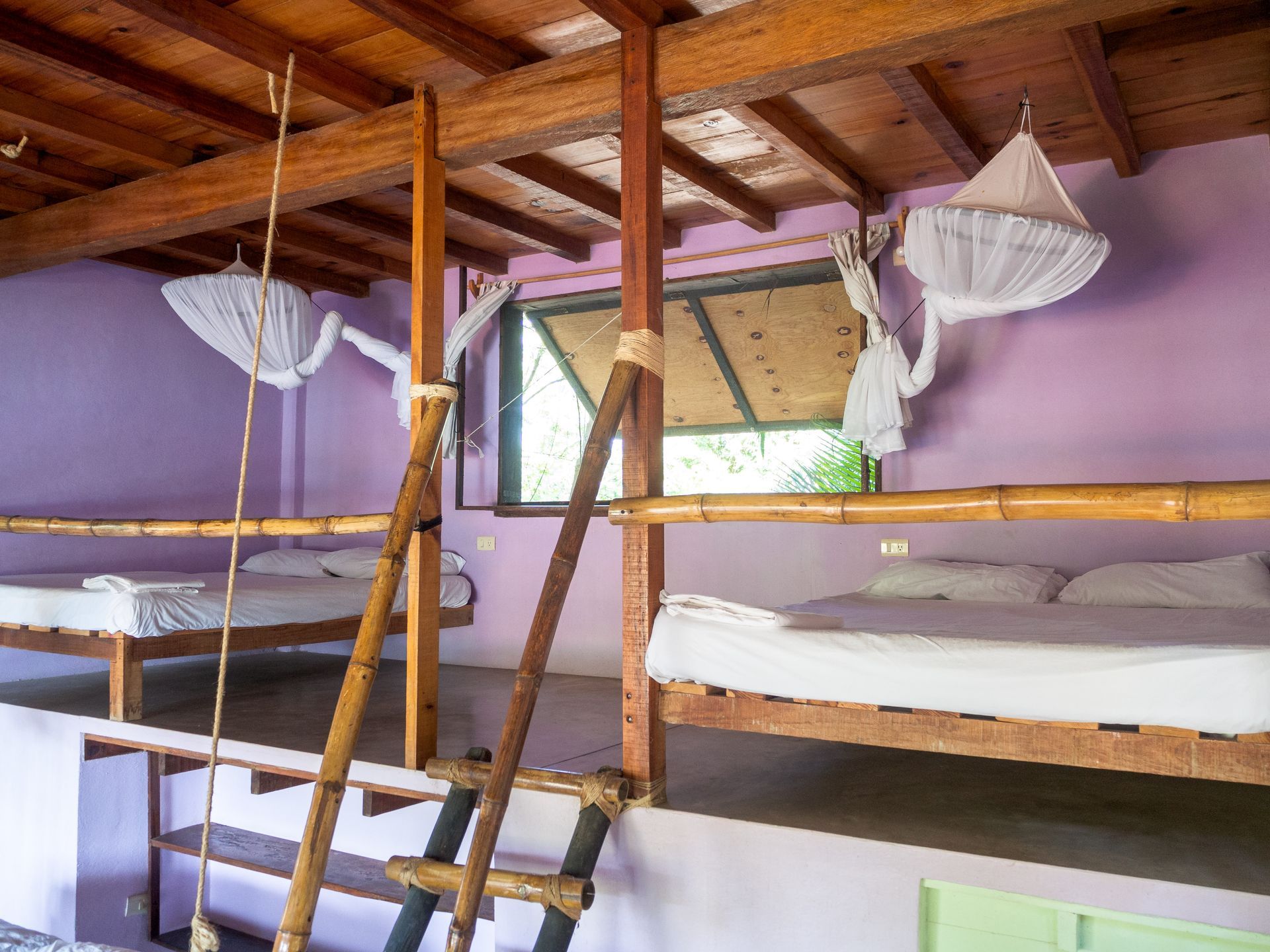 Literas en una habitación con techo de madera en posada del arquitecto