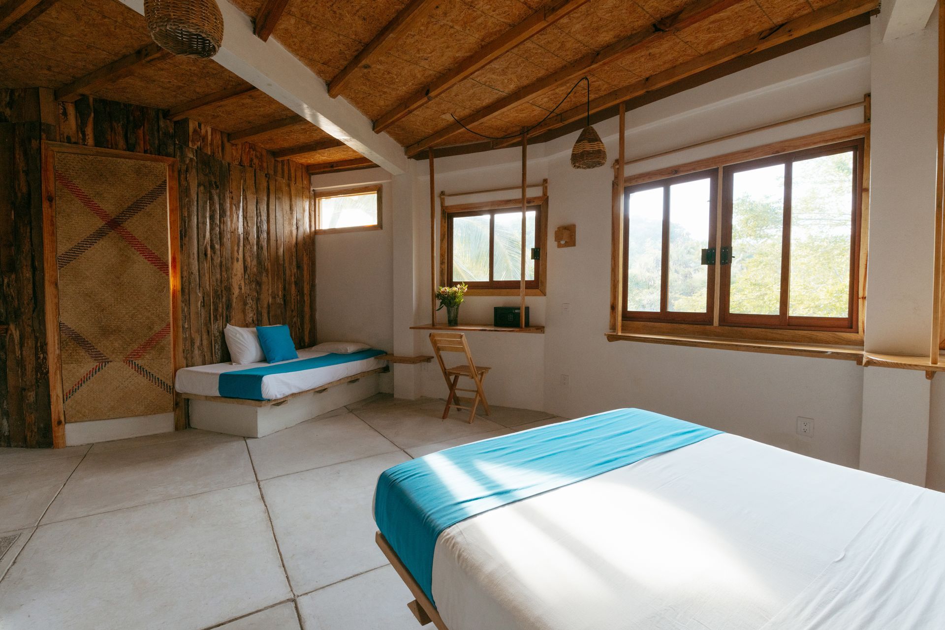 Dormitorio con techo y pared de bambú, dos camas con luz natural en posada del arquitecto en mazunte, oaxaca