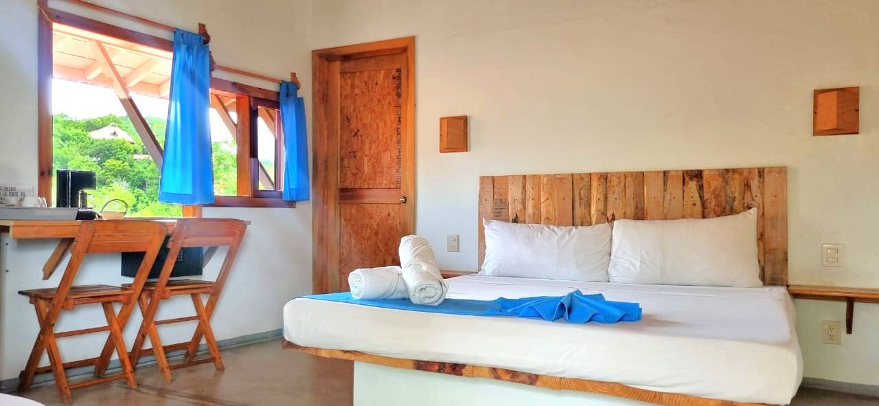 Dormitorio con cama rústica de madera en posada del arquitecto en mazunte, oaxaca
