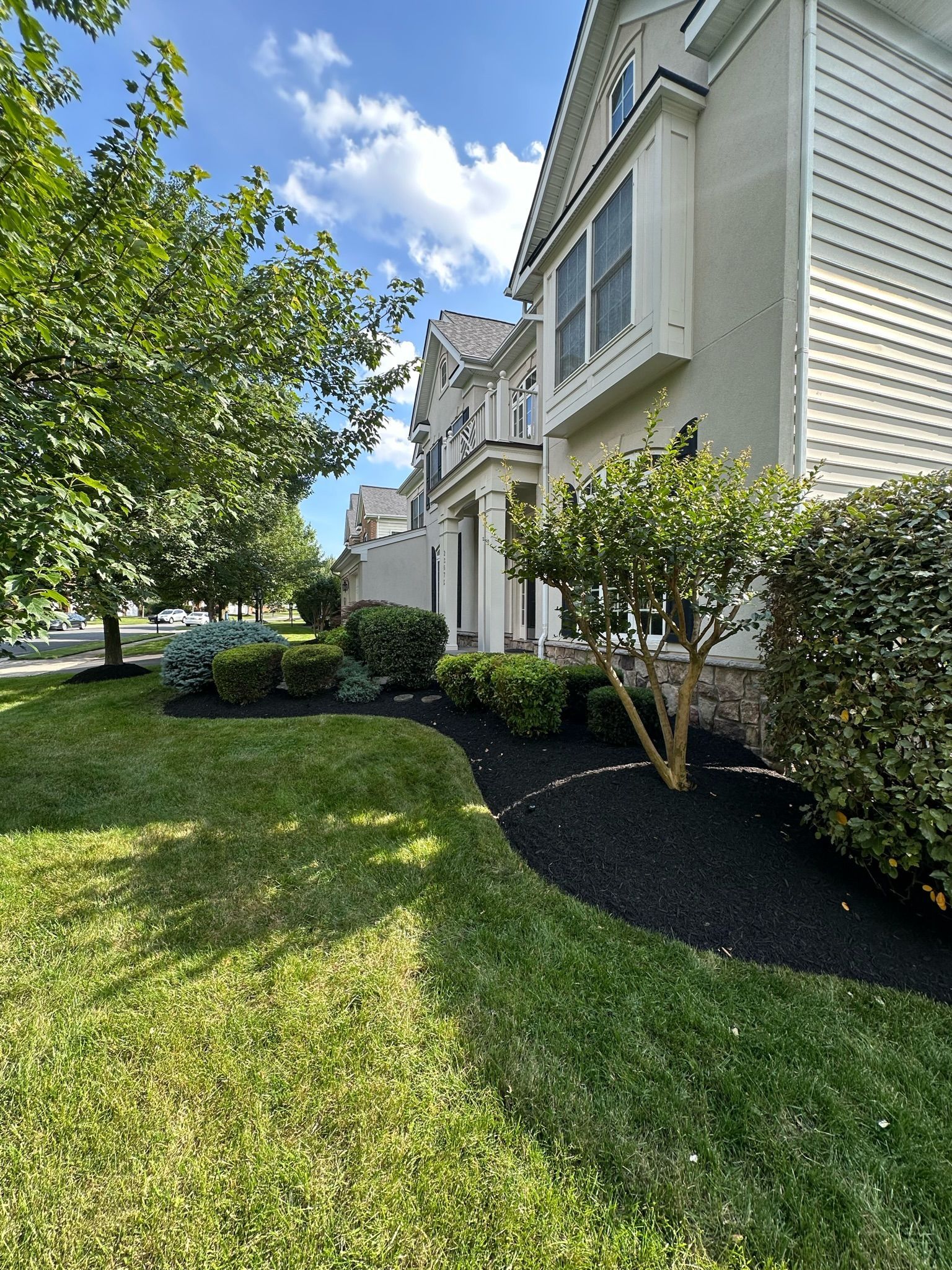 A large white house with a lush green lawn in front of it.