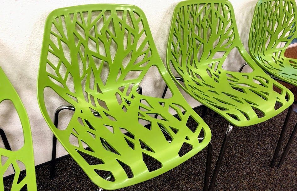A row of green chairs with a tree design on them