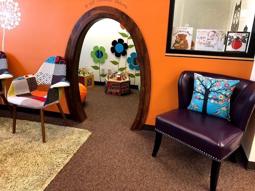 A waiting room with a purple chair and an orange wall
