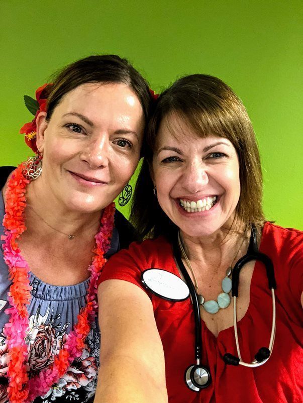 Two women are posing for a picture together and smiling for the camera.