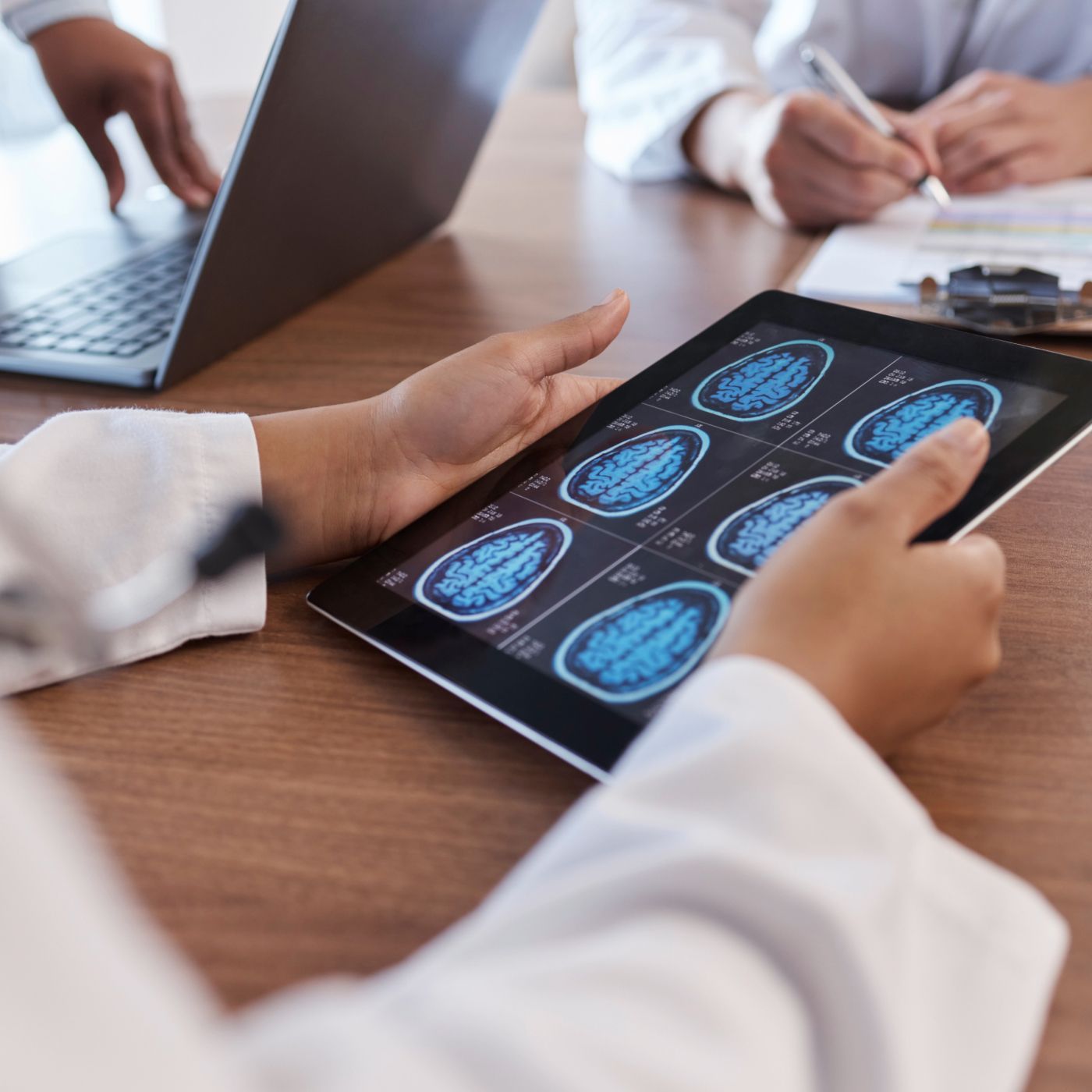 Person using a tablet with blue fingerprint scans during a meeting at a desk