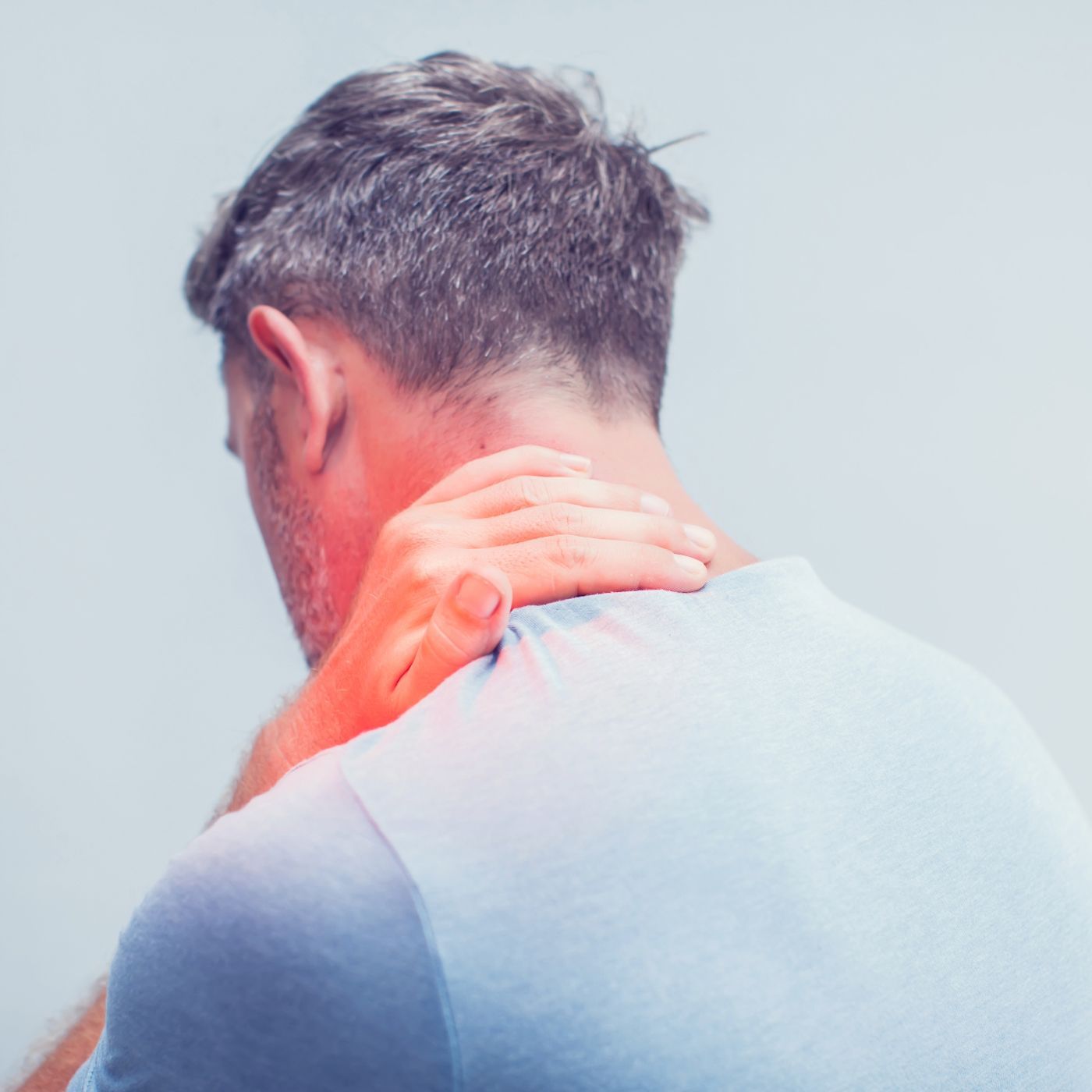 Person clutching the back of their neck, shown from behind with a red pain glow on the shoulder.