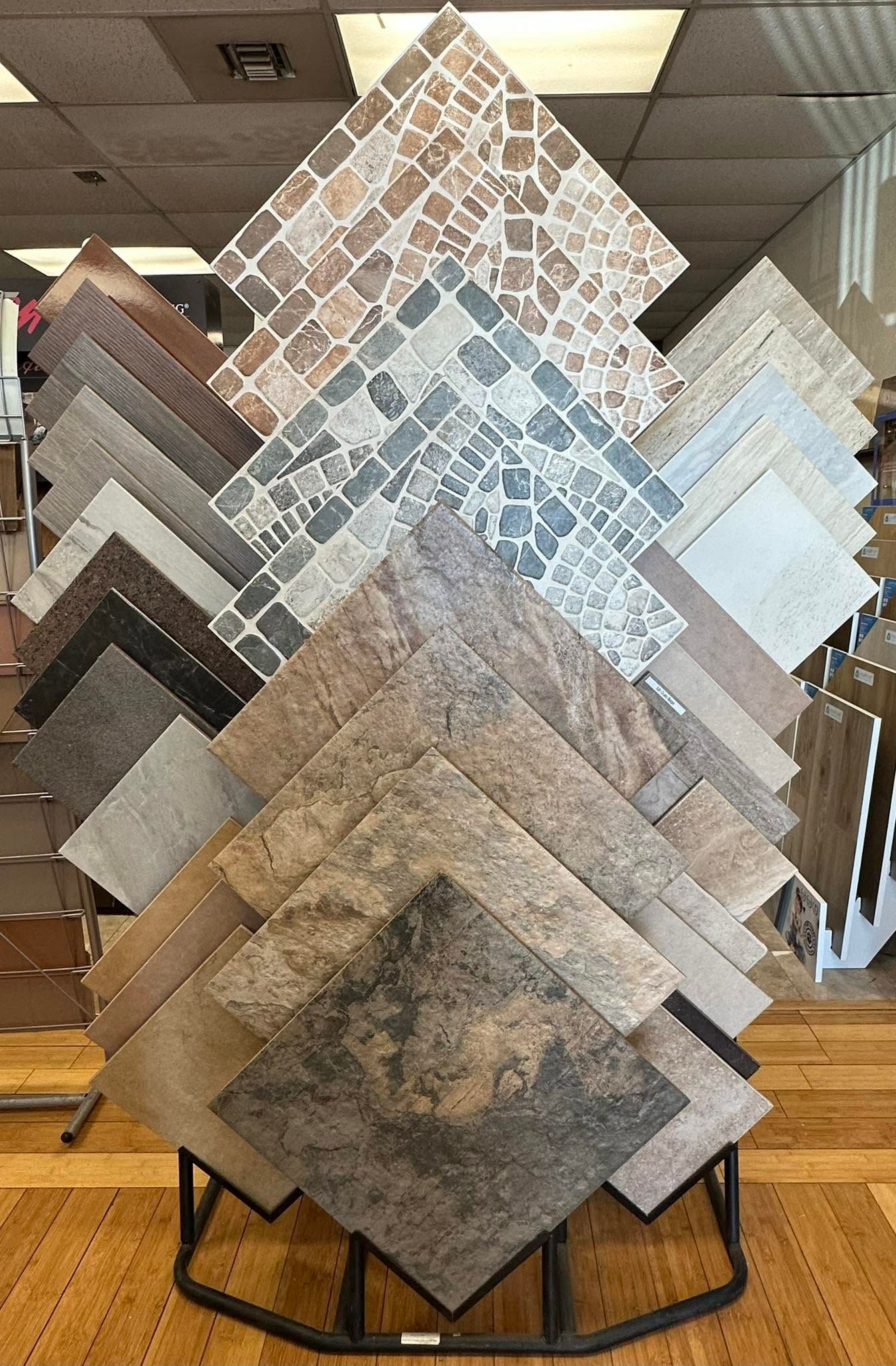 Tile display rack with sample ceramic floor tiles in assorted neutral patterns and colors