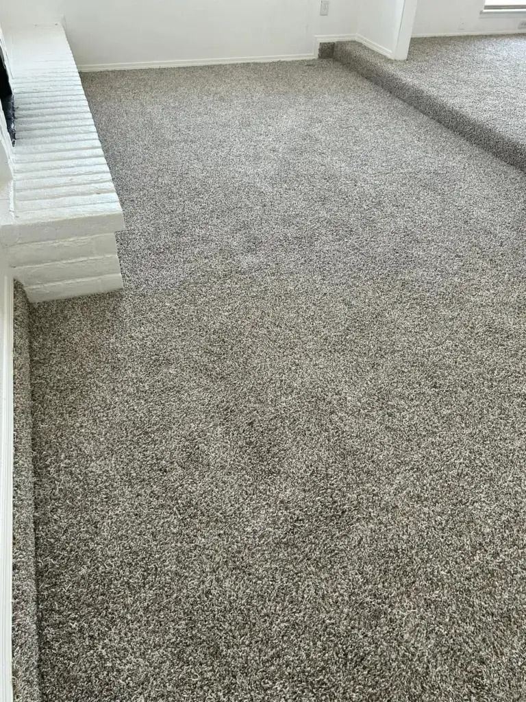 Gray carpeted room with white walls and a stepped ledge along the left side.