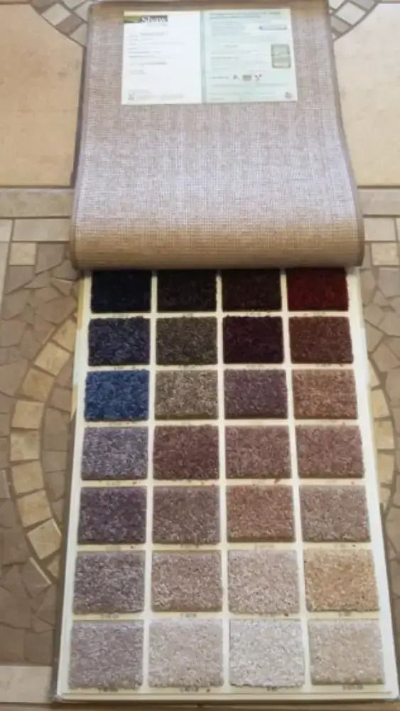 Open fabric swatch book with rows of textured color samples in beige, blue, purple, and brown.