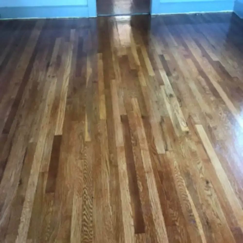 Empty room with polished wooden floor and light blue walls.