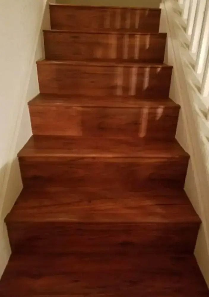 Wooden staircase with polished dark treads and white side rails indoors