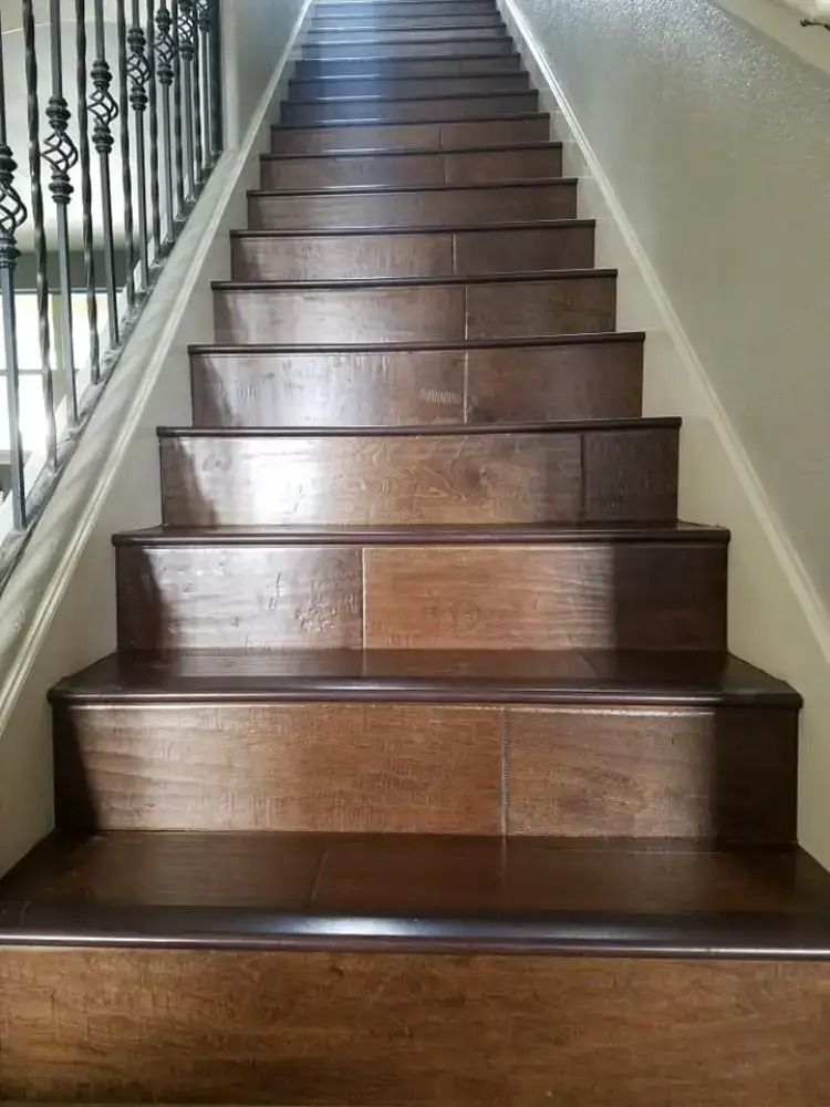 Wooden staircase with dark steps and a wrought-iron railing along the left wall.