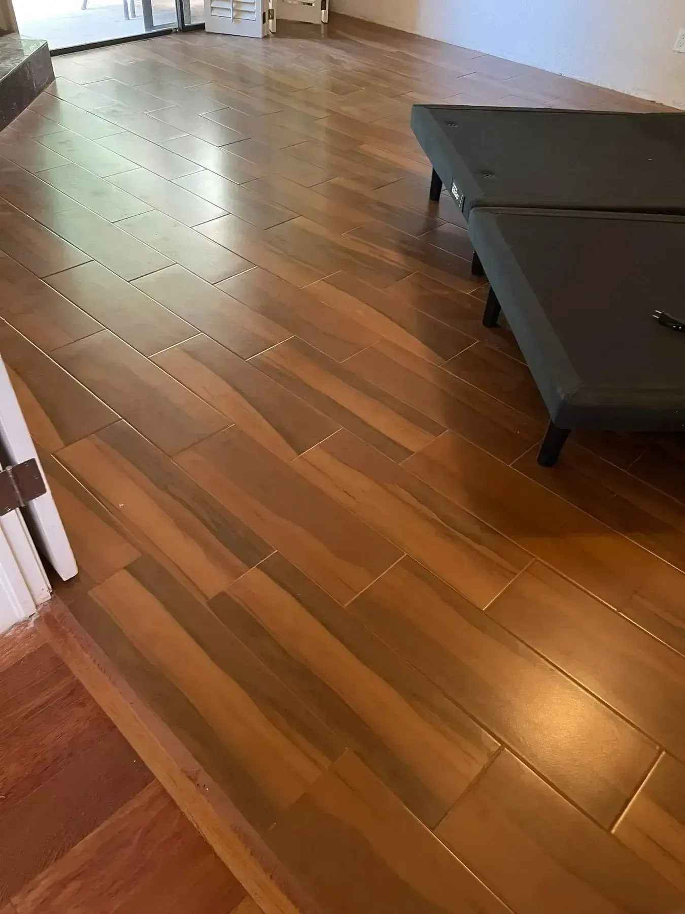 Empty room with polished hardwood floors and a dark coffee table on the right
