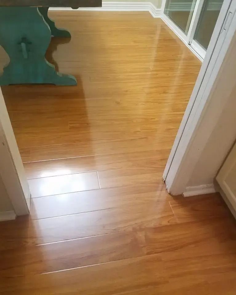 Wooden hallway floor with doorway and a green foam play mat on the left