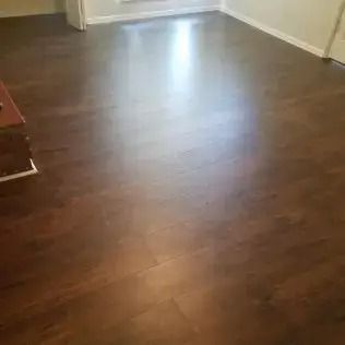 Empty room with polished dark hardwood floor and white walls