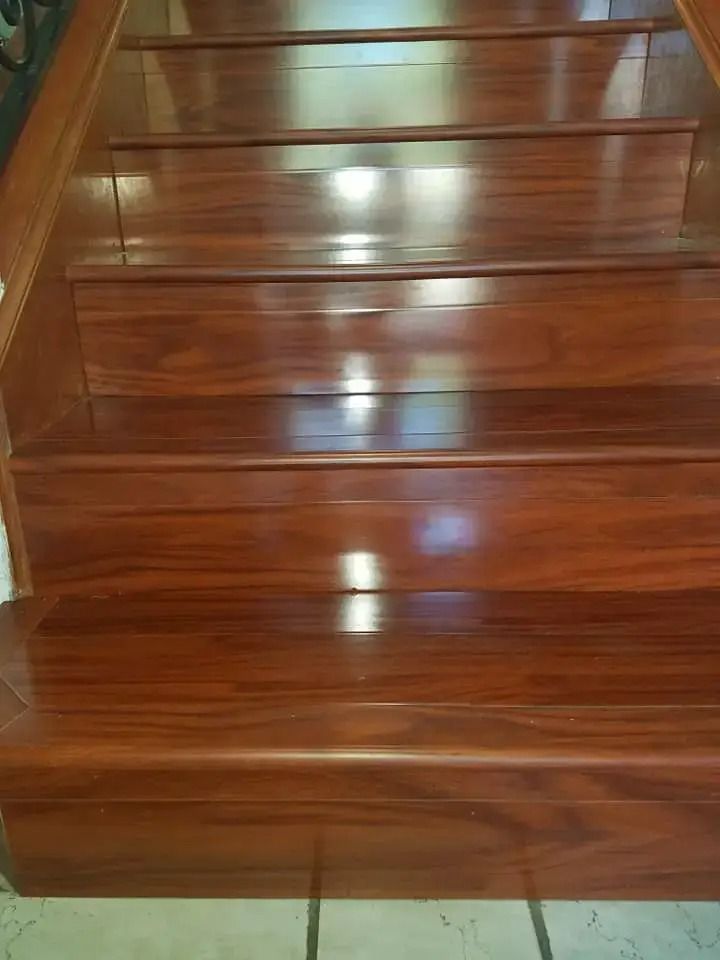 Wooden staircase with glossy brown steps and bright light reflections