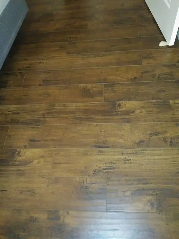 Empty room floor with dark wood planks and a white door frame.