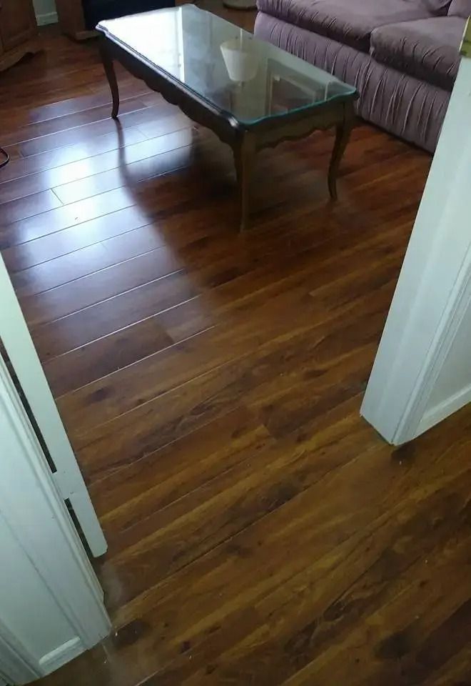 Living room with hardwood floor, glass coffee table, and purple sofa partly visible