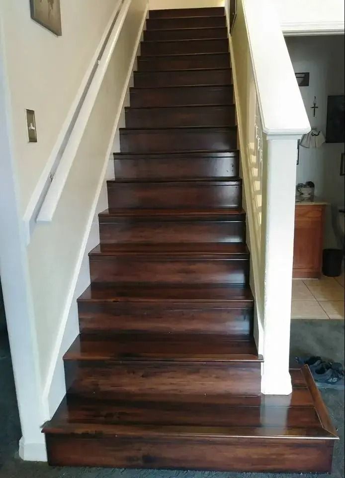 Dark wooden staircase with white railings in a home hallway