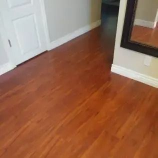 Empty room with warm wood floors, white doors, and a wall mirror